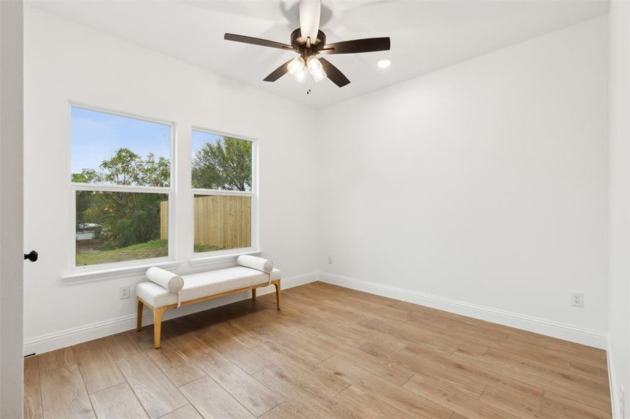 Unfurnished room with ceiling fan and light hardwood / wood-style flooring