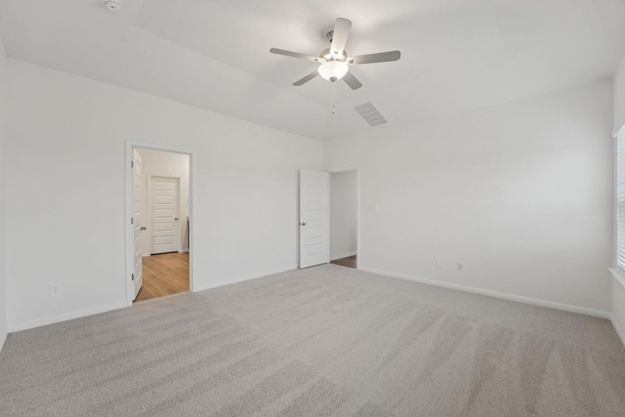 Unfurnished bedroom featuring light colored carpet and ceiling fan