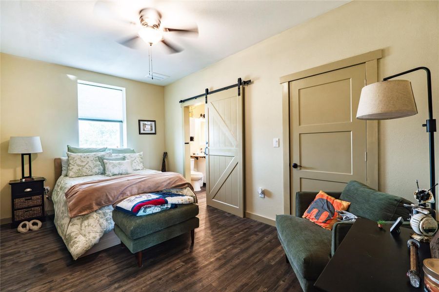 Primary bedroom featuring LVP flooring, barn door and ensuite bath Primary bedroom featuring LVP flooring, barn door and ensuite bath