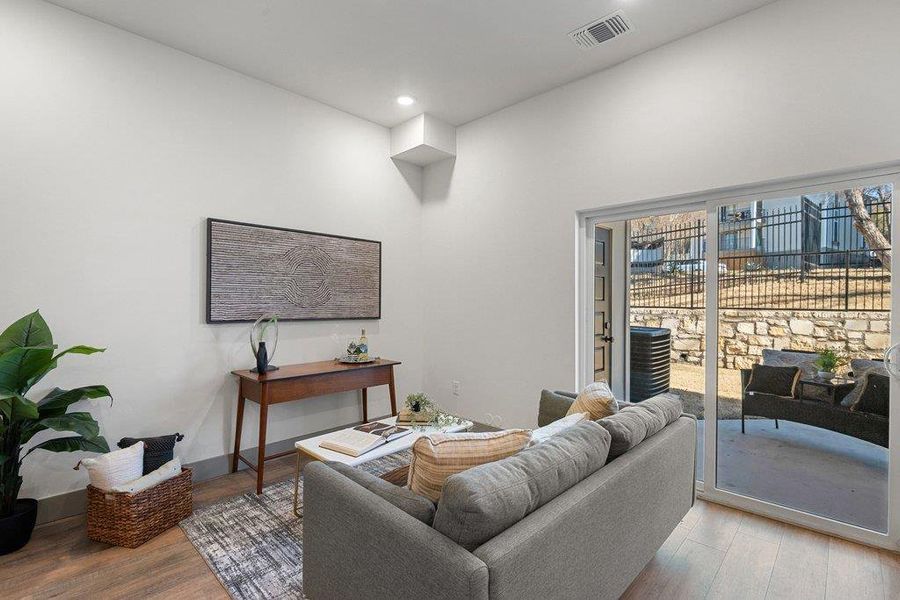 Living area with wood finished floors and recessed lighting
