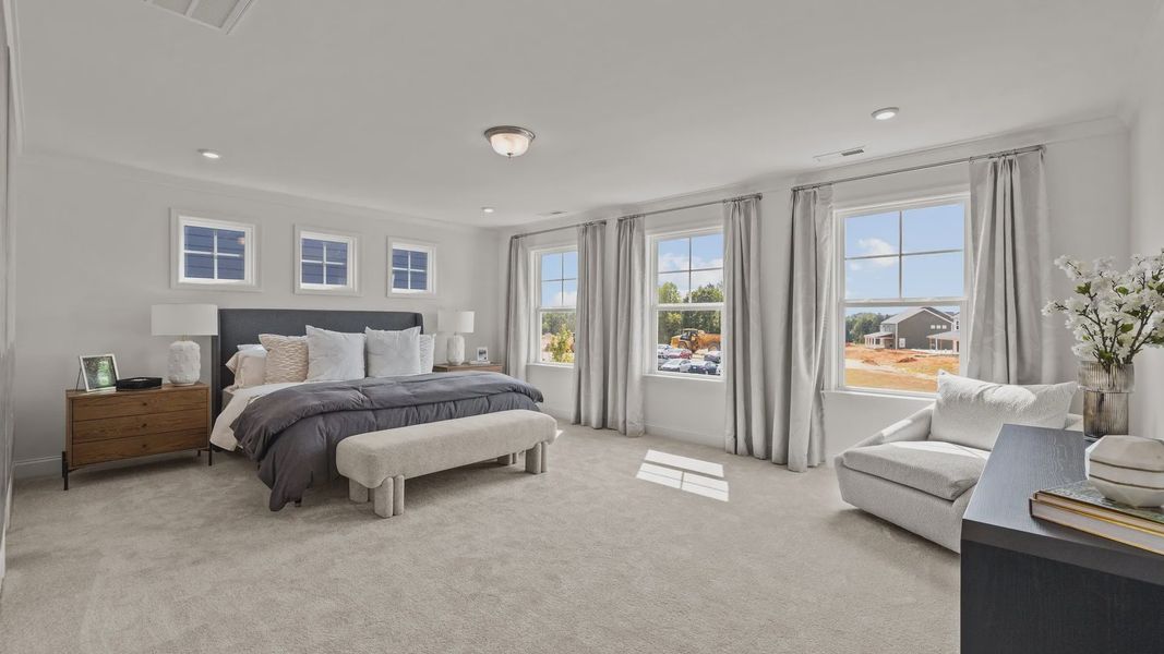 Bright and spacious primary bedroom with elevated ceiling and plentiful windows, in the Townsend Design by DRB Homes York, SC