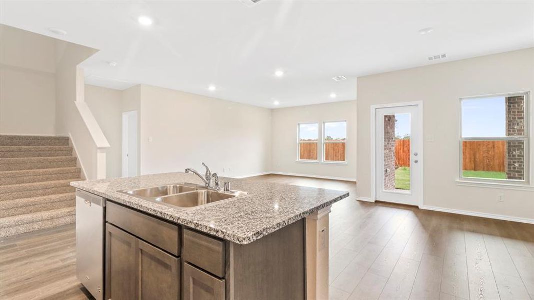 Kitchen island with a double basin stainless steel sink and granite countertop
