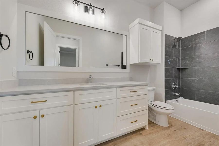 Bathroom featuring vanity, bathtub / shower combination, and light wood-type flooring