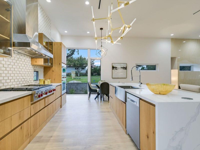 Culinary excellence meets modern design in this spacious kitchen, boasting an island with a sink and sweeping backyard views. Culinary excellence meets modern design in this spacious kitchen, boasting an island with a sink and sweeping backyard views.
