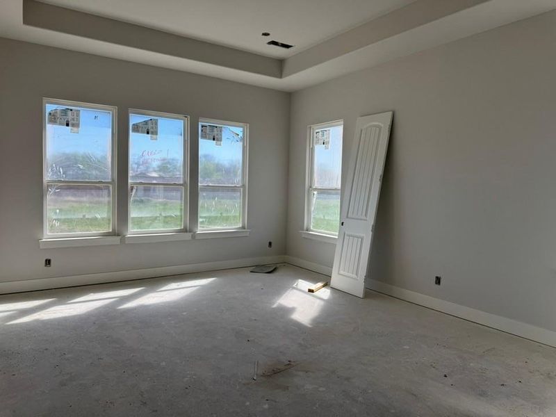 Empty room featuring baseboards and a raised ceiling