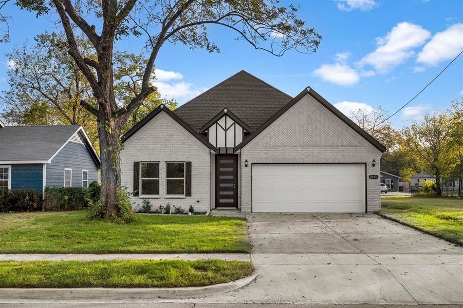 View of front of home featuring a front lawn and a garage