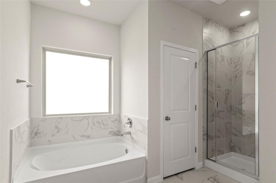 Bathroom featuring a bath, marble finish flooring, a marble finish shower, and recessed lighting