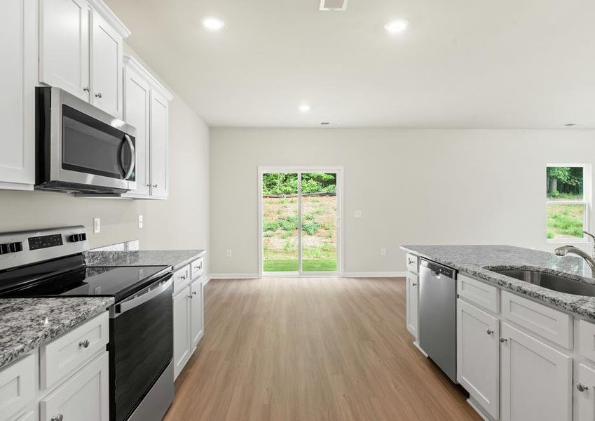 Kitchen complete with stainless steel appliances, granite countertops, cabinets with hardware and luxury vinyl plank flooring.