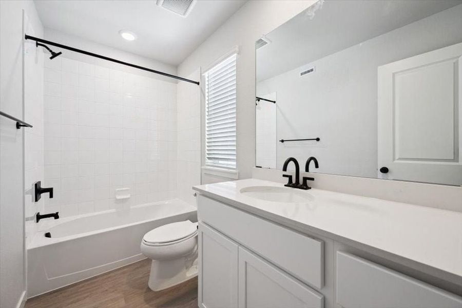 A bathroom with a tub toilet and sink.