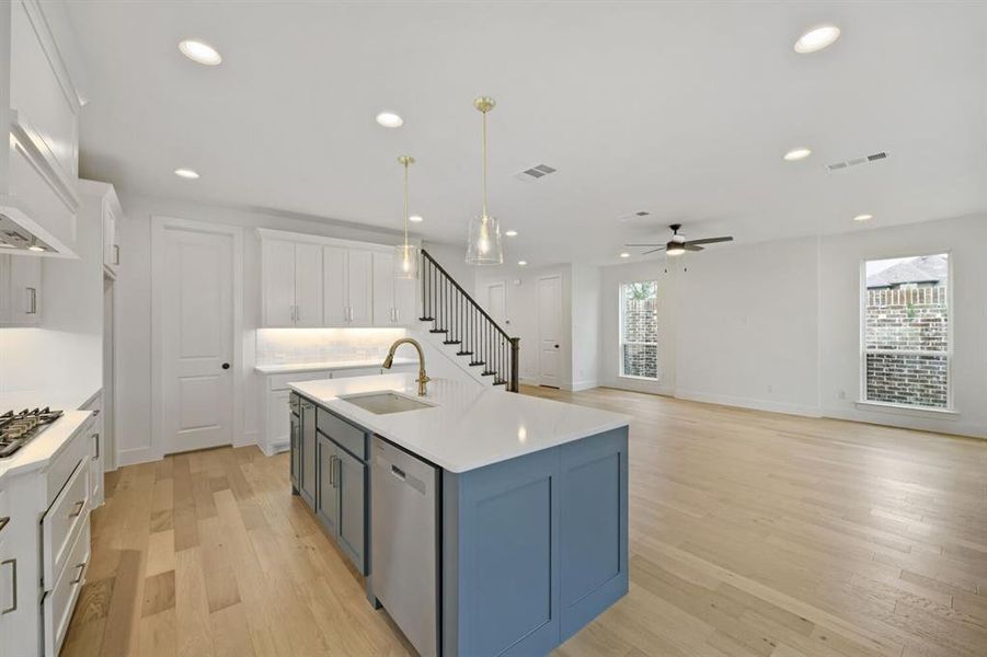 Open-concept living area with wood-finish flooring, recessed lighting, and a contemporary ceiling fan Open-concept living area with wood-finish flooring, recessed lighting, and a contemporary ceiling fan