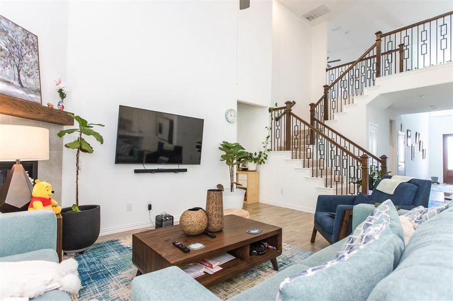 Living room with a high ceiling and light hardwood / wood-style floors