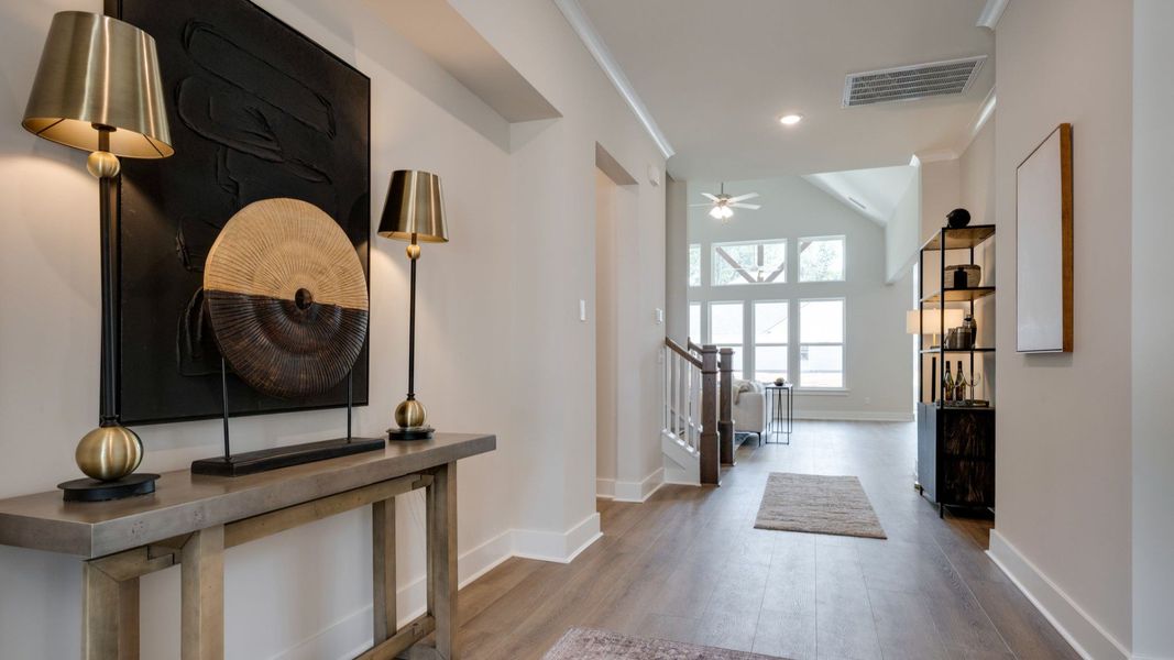Front door leading into hallway with hardwood flooring Front door leading into hallway with hardwood flooring