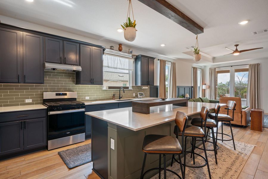 Kitchen featuring stainless steel range with gas stovetop, light wood finished floors, tasteful backsplash, plenty of natural light, and recessed lighting Kitchen featuring stainless steel range with gas stovetop, light wood finished floors, tasteful backsplash, plenty of natural light, and recessed lighting