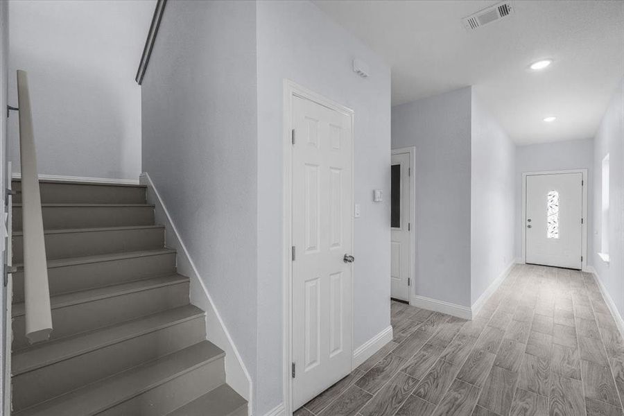 Entryway featuring wood finished floors, stairway, and recessed lighting