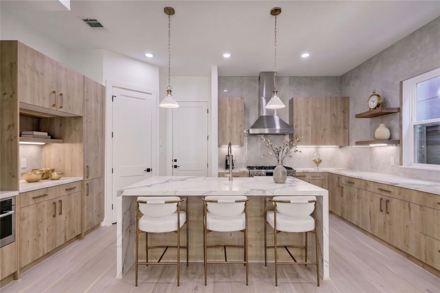 Kitchen – Located on the first floor, this beautifully designed kitchen features a double waterfall-edge island with quartz countertops, abundant cabinets, and a walk-in pantry. (virtual staging)