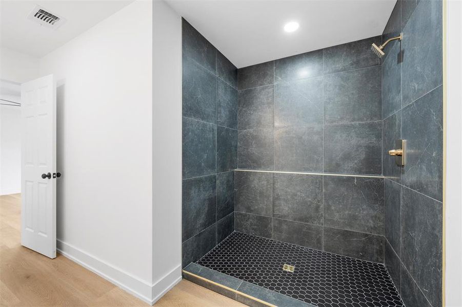 Bathroom with wood finished floors, tiled shower, and recessed lighting Bathroom with wood finished floors, tiled shower, and recessed lighting