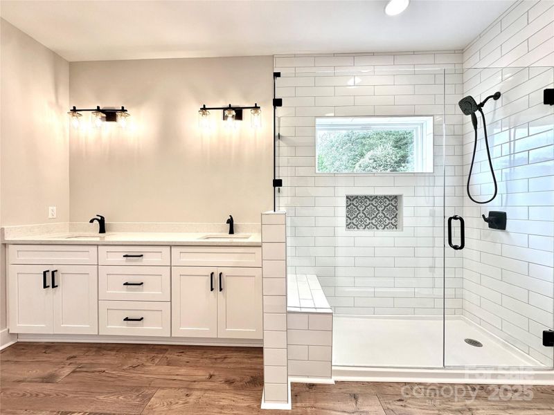 Primary Bath w/dual vanities, tile shower and transom bringing in natural light