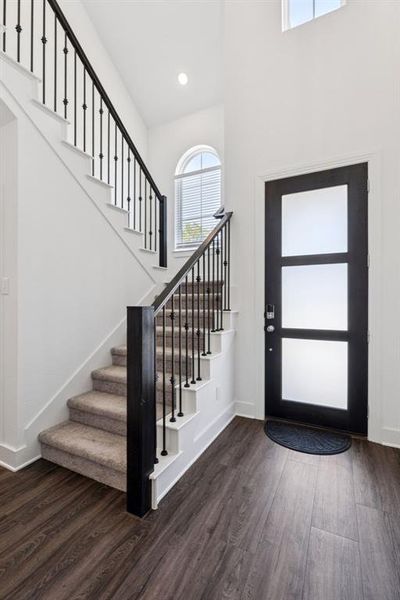 Foyer entrance with stairway, plenty of natural light, dark wood-style flooring, and recessed lighting Foyer entrance with stairway, plenty of natural light, dark wood-style flooring, and recessed lighting