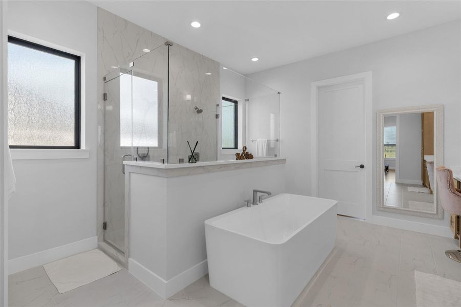 Luxurious primary bath with soaking tub and walk-in shower.