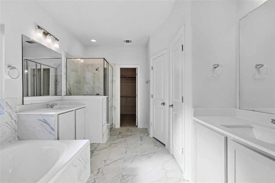 Bathroom featuring tile floors, dual vanity, and shower with separate bathtub