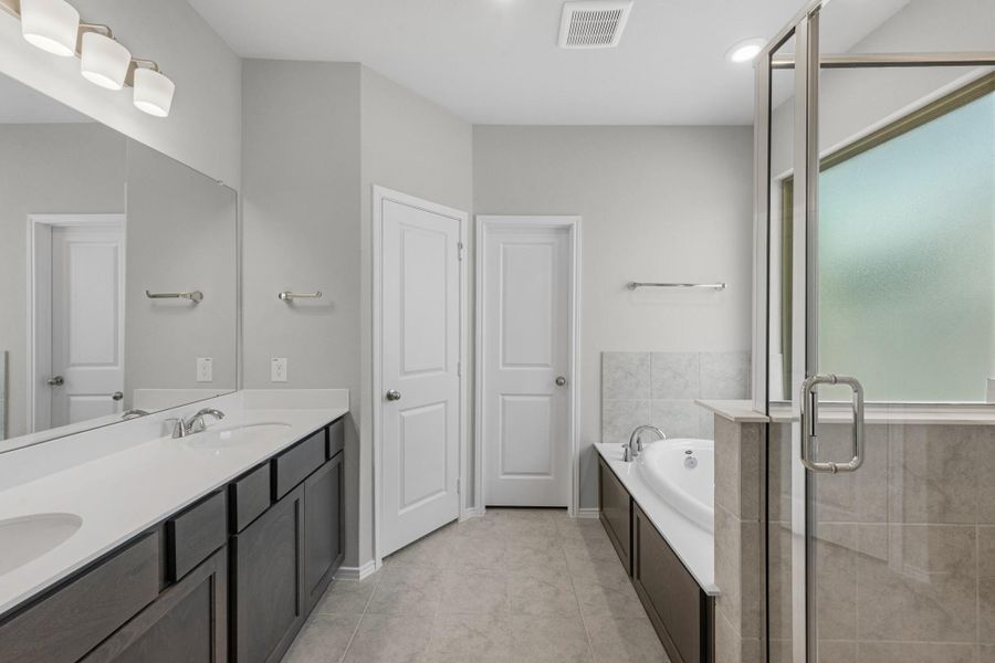 Double sinks, separate tub, and shower in the primary bathroom.