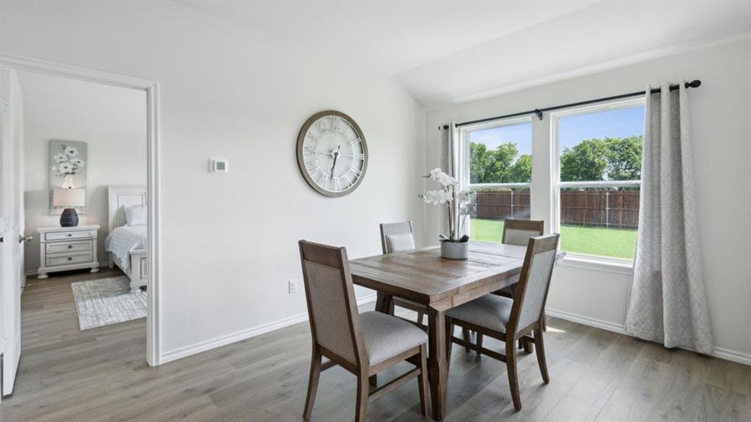 Dining space featuring vaulted ceiling and light wood-style flooring