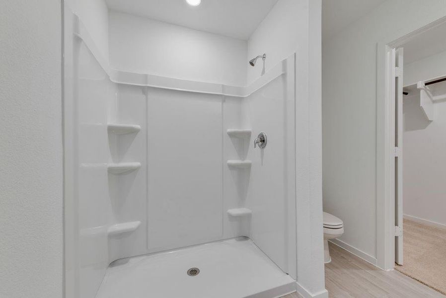Bathroom featuring a shower stall and wood finished floors