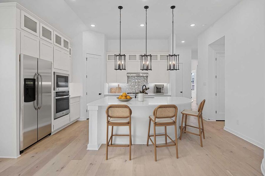 Kitchen featuring stainless steel appliances, backsplash, light countertops, white cabinetry, and recessed lighting