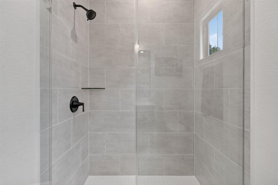 A well-appointed shower stall features sleek tiling and modern fixtures. A well-appointed shower stall features sleek tiling and modern fixtures.