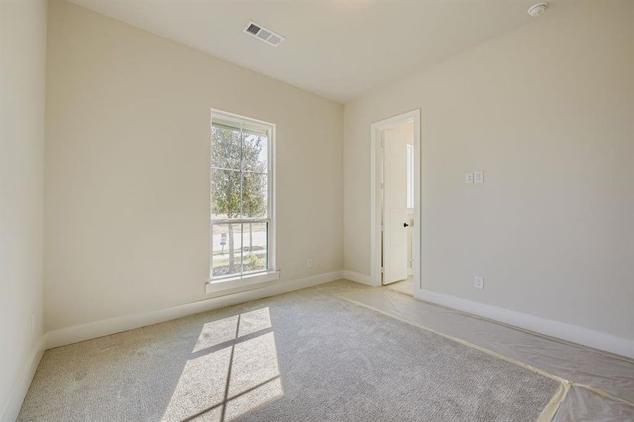 Carpeted spare room featuring baseboards
