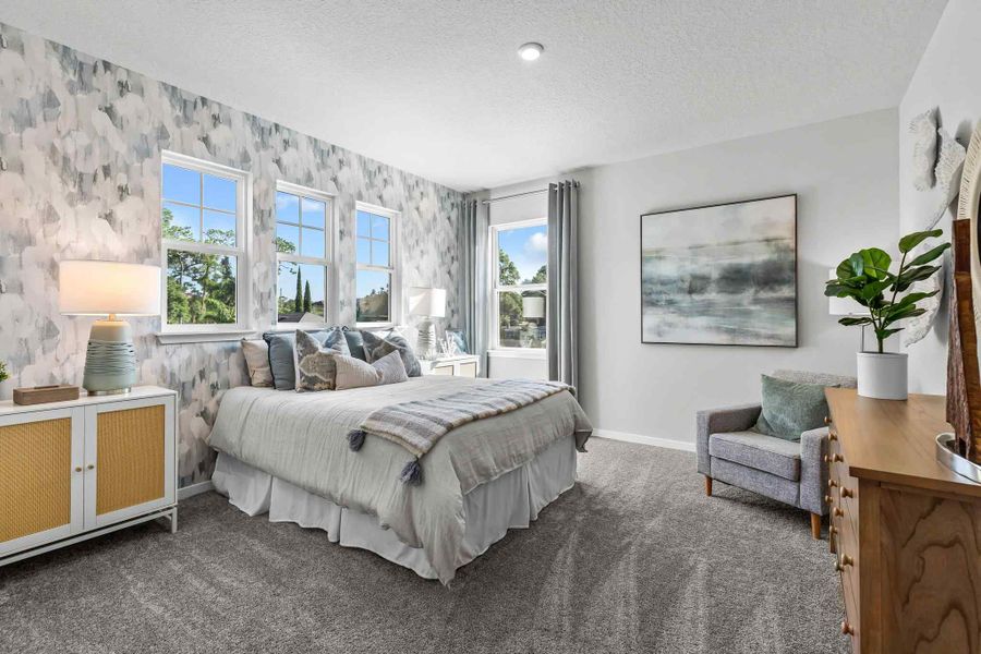 A bedroom with a bed and a chair.