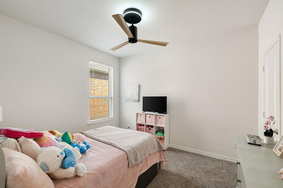 Bedroom with carpet flooring and a ceiling fan Bedroom with carpet flooring and a ceiling fan