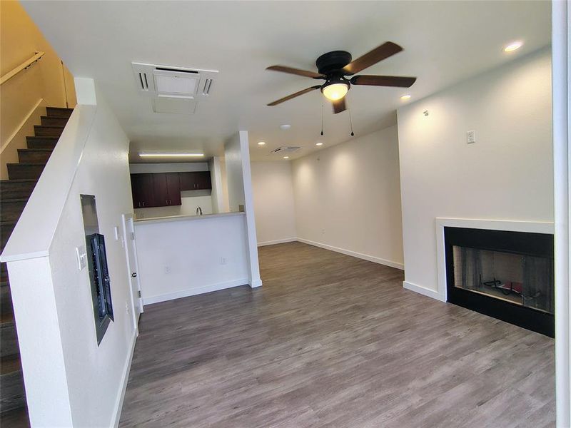 Unfurnished living room featuring ceiling fan and wood-type flooring