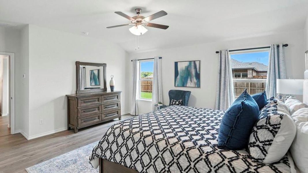 Bedroom featuring vaulted ceiling, light wood-style flooring, and a ceiling fan Bedroom featuring vaulted ceiling, light wood-style flooring, and a ceiling fan