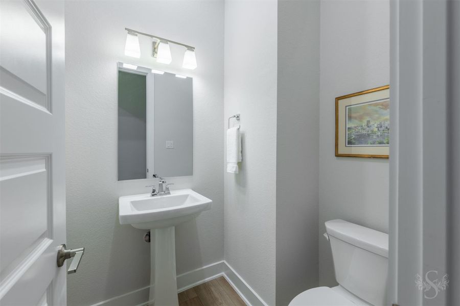 A chic powder bath offers guests a polished space with a pedestal sink, contemporary lighting and crisp modern finishes. A chic powder bath offers guests a polished space with a pedestal sink, contemporary lighting and crisp modern finishes.