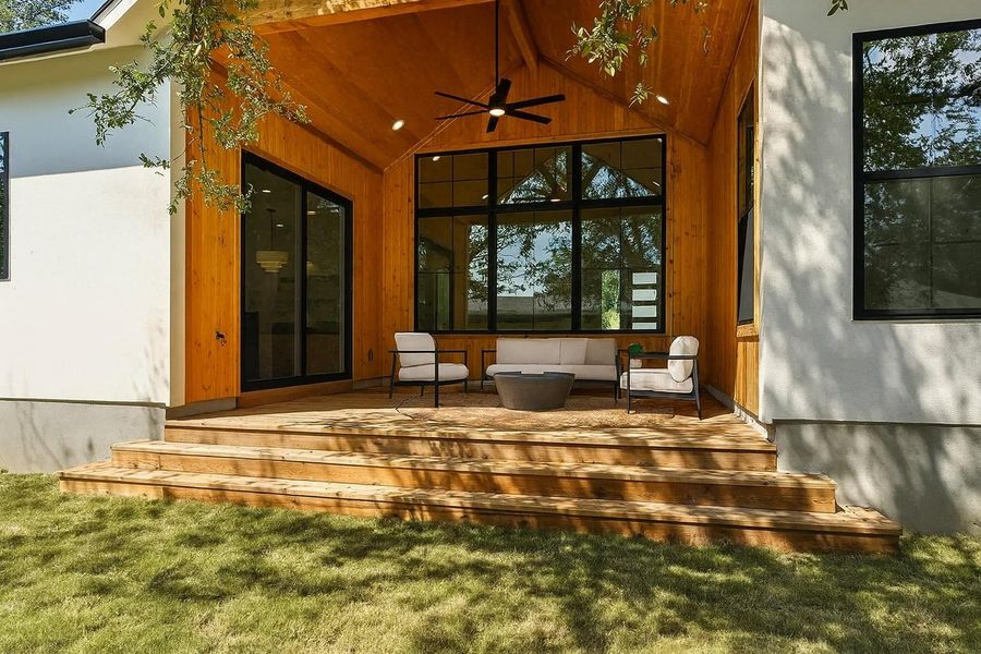 Rear view of house featuring a ceiling fan and a yard Rear view of house featuring a ceiling fan and a yard