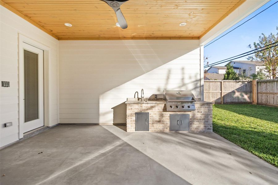 Your covered patio extends your living space, featuring a warm wood-plank ceiling, recessed lighting, and a ceiling fan that make outdoor lounging comfortable in every season.