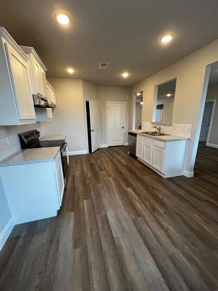 Kitchen with extractor fan, dishwasher, white cabinets, range, and dark wood-type flooring