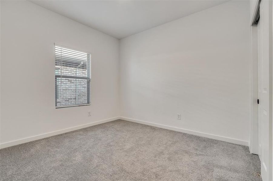 Empty room featuring light colored carpet and baseboards Empty room featuring light colored carpet and baseboards