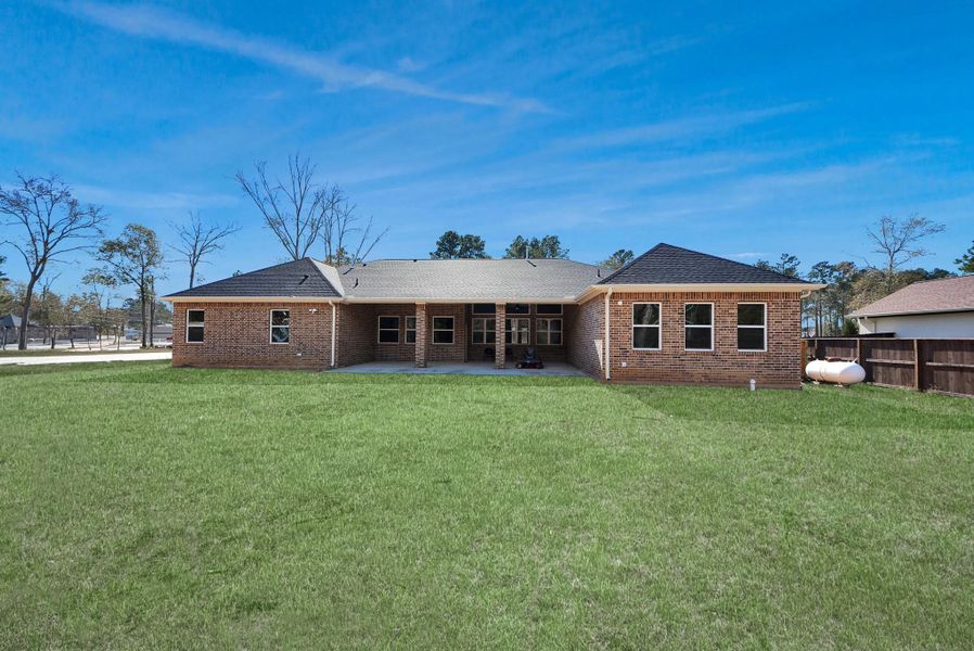 The back of the home is all brick and contains a covered patio area.