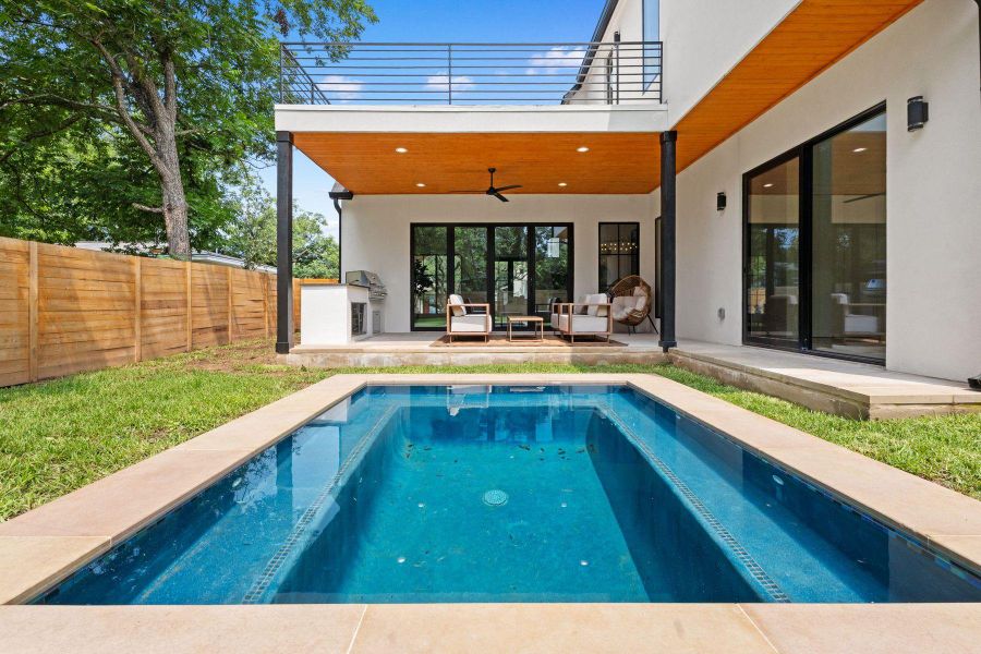 An inviting backyard oasis offers a sparkling in-ground pool and covered patio with outdoor kitchen, perfect for entertaining. An inviting backyard oasis offers a sparkling in-ground pool and covered patio with outdoor kitchen, perfect for entertaining.