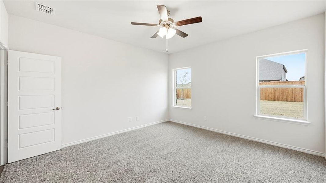 Carpeted empty room with baseboards and ceiling fan