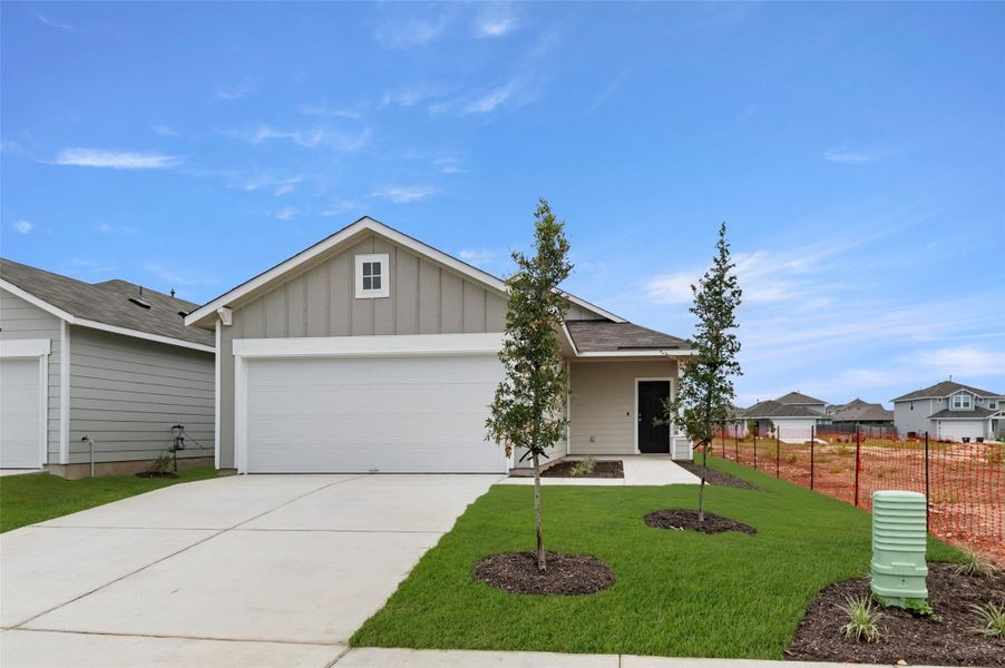 View of front of house with board and batten siding, driveway, and an attached garage