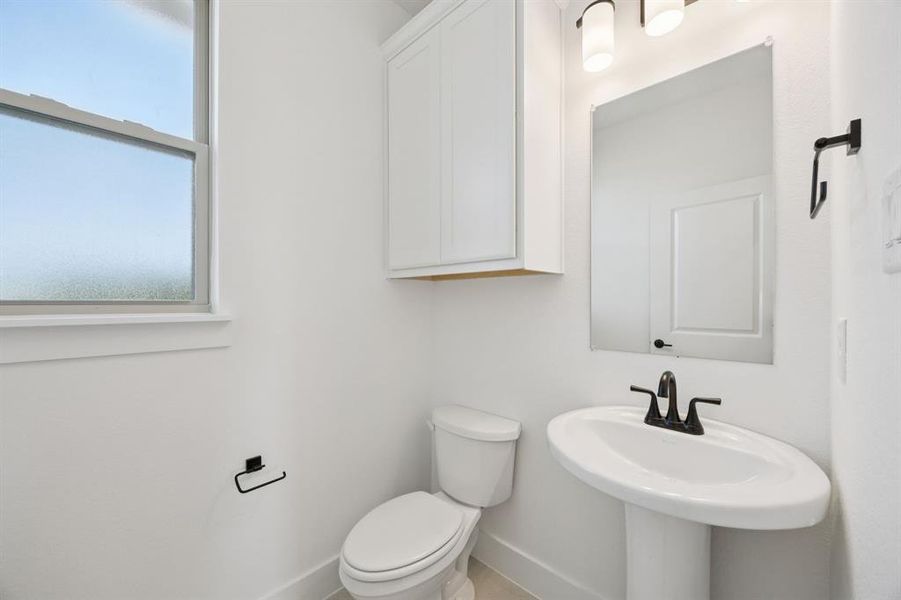 Bathroom featuring toilet and baseboards Bathroom featuring toilet and baseboards