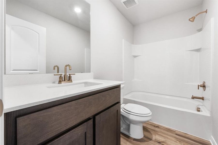 Full bathroom featuring shower / bathtub combination, hardwood / wood-style flooring, vanity, and toilet