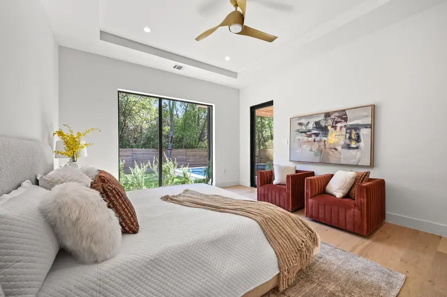 Bedroom featuring a raised ceiling, access to outside, light wood finished floors, recessed lighting, and a ceiling fan