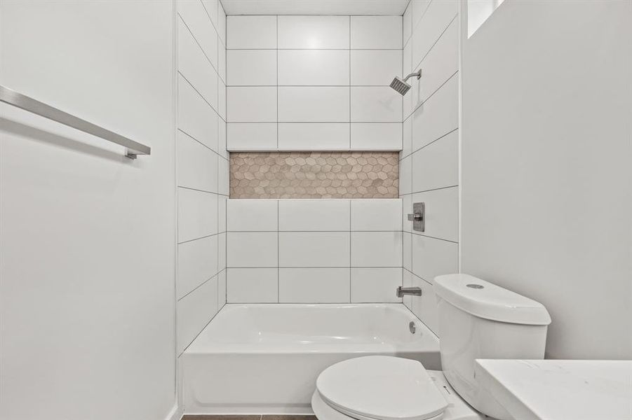 Bathroom with tiled shower / bath and toilet