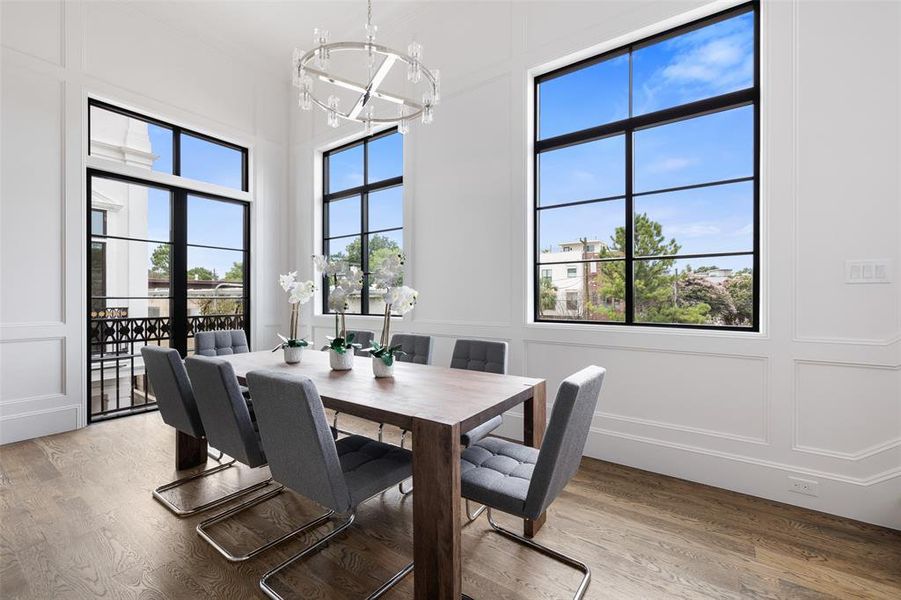 The dining area benefits from abundant natural light. The custom-stained hardwoods gleam under the filtered sunlight in this lovely space. Image from previously completed home in the community.