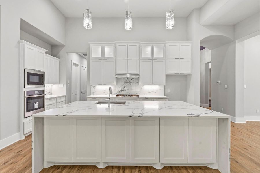The oversized island offers exceptional prep space and abundant storage while anchoring this beautifully appointed kitchen.