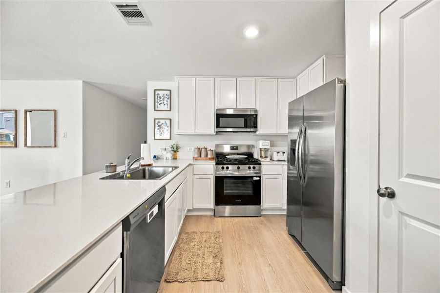 Sleek modern kitchen with stainless steel appliances, white cabinetry, and a spacious island for entertaining.